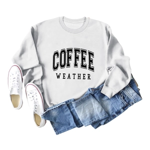 Flat lay of a white crewneck sweatshirt with black COFFEE WEATHER text and denim jeans