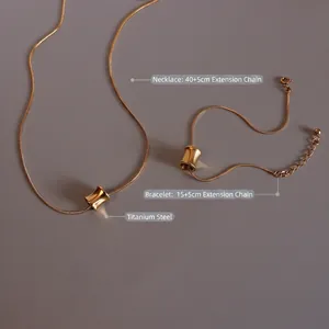 Titanium steel necklace and bracelet set in 18K gold finish with cylinder charms