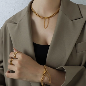 Conjunto de collar y pulsera de cadena dorada con anillos en una modelo femenina