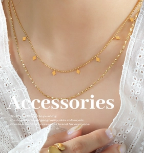 Close-up of double-layered gold choker with geometric rhombic pendants on a female model