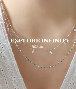 Detail of silver double-layered necklace with geometric diamond charms on a model