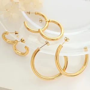 Three sizes of C-shaped 18K gold plated titanium steel hoop earrings on glass