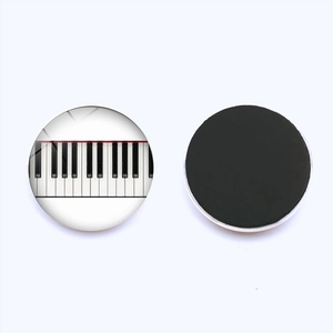 Round piano key fridge magnet with glass dome and magnetic backing on white background