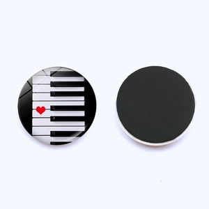 Detail of round piano keys fridge magnet with red heart and black magnetic back view
