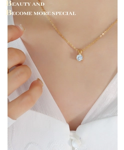 Close-up of minimalist 18K gold titanium necklace with a single round zircon pendant