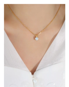 Detail of single zircon pendant on 18K gold titanium steel necklace on a model's neck