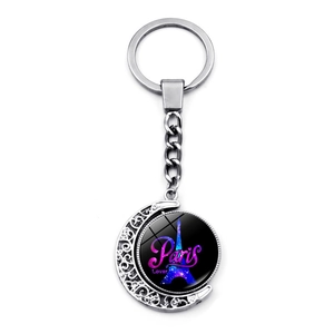 Close-up of rotating silver moon keychain featuring Eiffel Tower glass cabochon