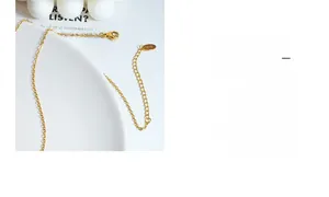 Detail of 18K gold-plated titanium chain with adjustable clasp and logo tag engraving