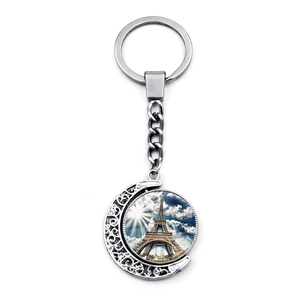 Close-up of a silver moon keychain featuring a rotating Eiffel Tower glass cabochon pendant