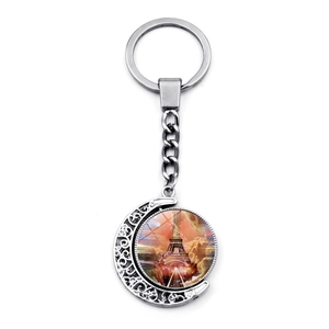 Detail of silver moon keychain with glass pendant showing the Eiffel Tower at sunset