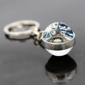Macro shot of silver Eiffel Tower keychain featuring a glass dome with Paris landscape