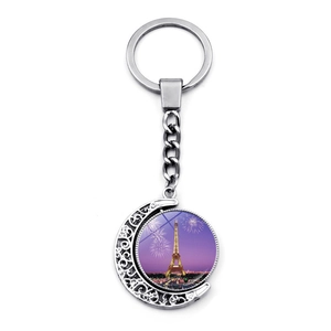 Rotating Eiffel Tower keychain with silver crescent moon frame and night sky glass pendant