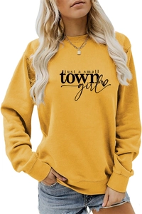 Detail of just a small town girl print on a yellow crewneck sweatshirt with cotton texture
