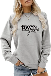 Close-up of 'just a small TOWN girl' text and heart print on a grey cotton sweatshirt