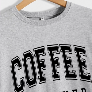 Classic grey crewneck sweatshirt featuring a bold black COFFEE varsity print on wood hanger