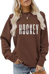 Close-up of brown crewneck sweatshirt featuring white HOCKEY wife printed graphic