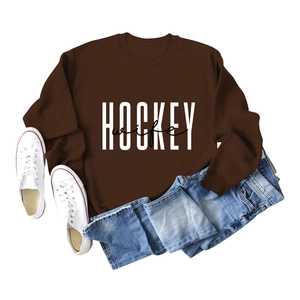 Flat lay of brown long sleeve sweatshirt with Hockey Wife print and denim jeans