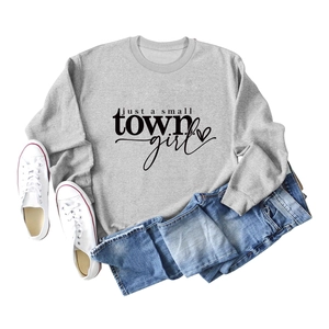 Grey crewneck sweatshirt featuring just a small town girl slogan with jeans and sneakers