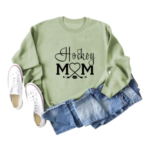 Sage green Hockey Mom sweatshirt paired with jeans and white sneakers on white background