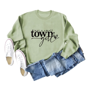Flat lay of light green sweatshirt with 'just a small town girl' print and heart detail