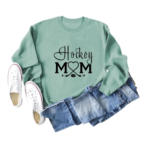 Detailed flat lay of green Hockey Mom sweatshirt with sticks and puck heart design