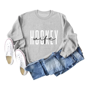 Flat lay of gray Hockey Wife crewneck sweatshirt with blue jeans and sneakers