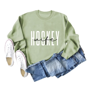 Flat lay of a grass green round neck sweatshirt with HOCKEY wife print and denim jeans