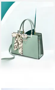 Détail d'un sac à main en cuir PU vert menthe avec logo doré et foulard en soie chic