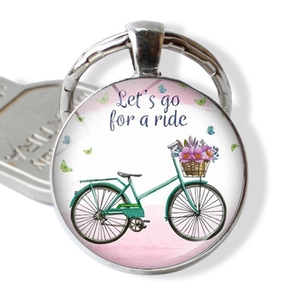 Detail of vintage bicycle pendant with floral basket and Let's go for a ride text