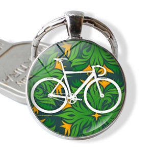 Vintage bicycle glass dome keychain with green floral scroll pattern on silver metal frame