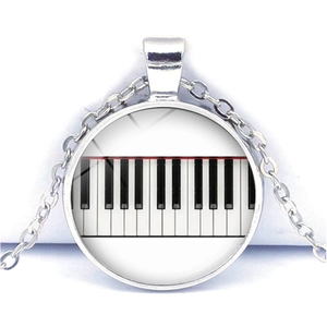 Detail of the piano key pattern inside the circular glass cabochon heart necklace