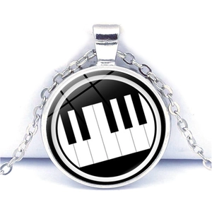 Detail of the piano key heart pattern under a glass dome on this stainless necklace