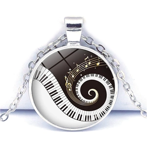 Detailed close-up of piano key heart necklace with golden musical notes and silver chain