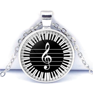 Detail view of heart piano keys and treble clef musical glass dome pendant
