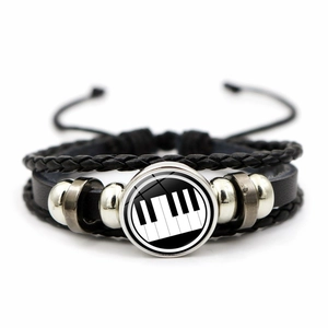 Detailed close-up of multilayer leather bracelet with piano keys glass charm and beads