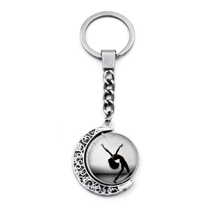 Silver ballerina silhouette keychain with rotatable moon pendant and filigree details