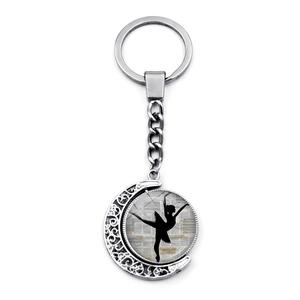 Detailed view of silver crescent moon keychain with rotating ballet dancer silhouette charm