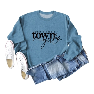 Flat lay of foggy blue crewneck sweatshirt with just a small town girl print and denim shorts