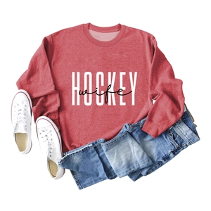 Detail of red crewneck sweatshirt with Hockey Wife print and white canvas sneakers