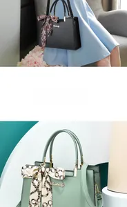 Détail d'un sac à main en cuir grainé avec poignée foulard et finitions dorées