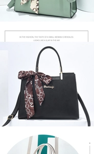 Détail du sac à main noir en cuir grainé avec foulard décoratif et logo en métal doré