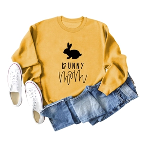 Flat lay of mustard yellow sweatshirt with black bunny mom print and ribbed cuffs