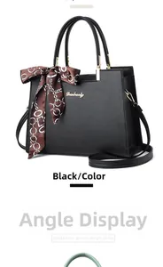 Détail du sac à main en cuir grainé noir avec foulard en soie et logo doré