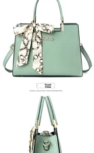 Détails du sac à main vert menthe avec foulard en soie et logo de la marque doré