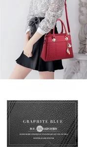 Détail de la texture cuir grainé rouge et pompon sur sac à main pour femme