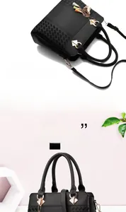 Détail d'un sac à main noir à motif litchi avec boucle dorée et pendentif à pompon coloré