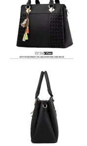 Détail d'un sac cabas en cuir noir avec texture matelassée et breloques dorées