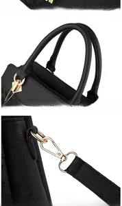 Détails du sac en cuir noir avec pompons, ferrures dorées et coutures précises