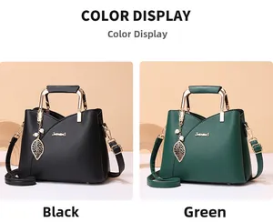 Detail view of black and green leather handbags with unique metal handles and leaf pendants