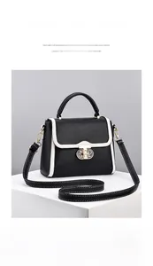 Détails du sac à main en cuir noir avec liseré blanc et boucles métalliques dorées